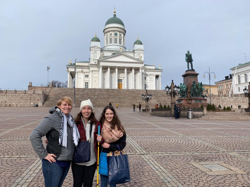 Laurel, Sarah and their friend Heather, who volunteered to help, stand in front of Helsinki's famous Rock Church.