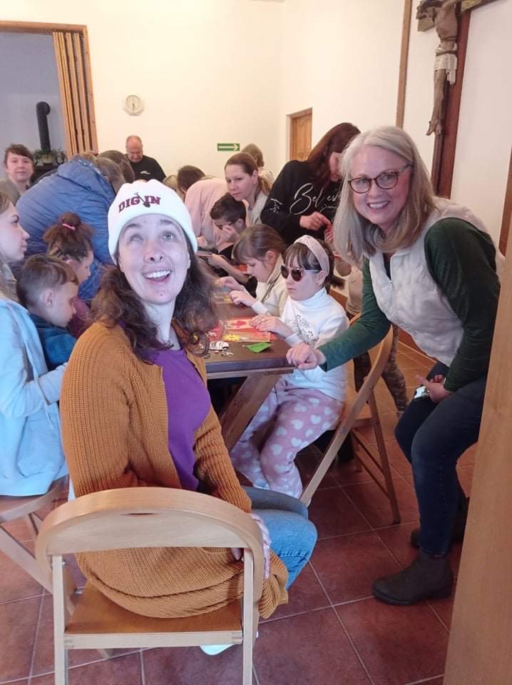 Laurel and her mother Jamie work at a table with students at the Laski School for the Blind in Warsaw, Poland.